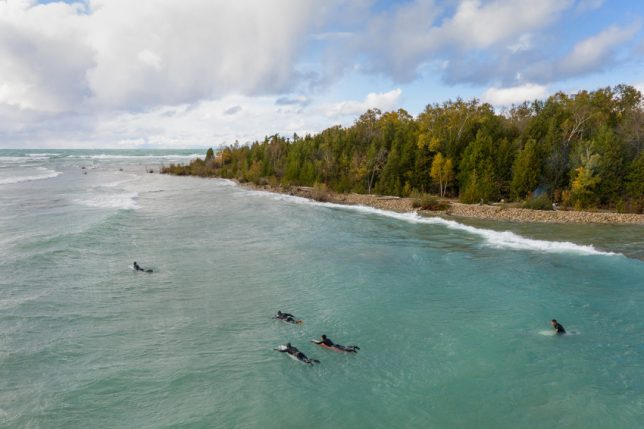 Surfers taking to water during an autumn storm on Lake Huron